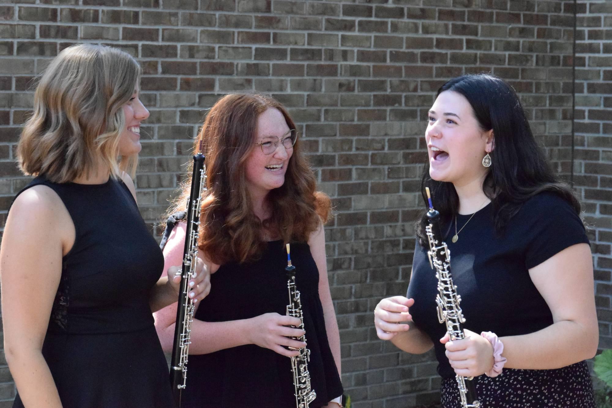 Lea卡特, 娜塔莉·克莱恩, and Natalie Feldpausch holding their oboes in the Marcia Haas garden at HCPA.